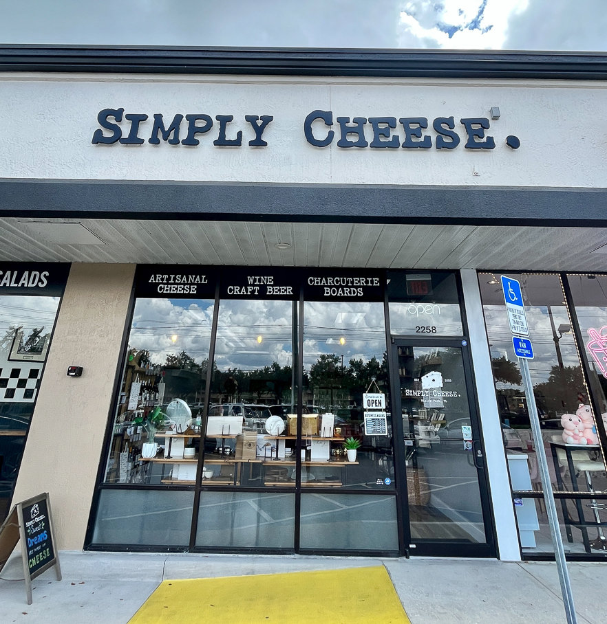 simply cheese front of building with white sign